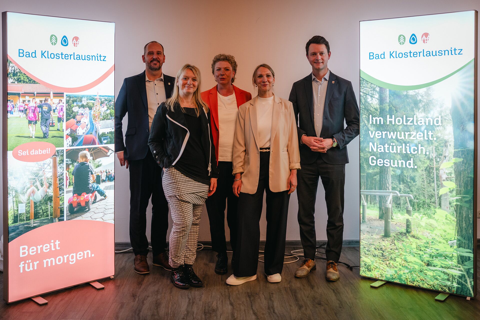 Pressefoto vor Leuchtdisplays mit neuem Markenauftritt von Bad Klosterlausnitz: Bürgermeister Kevin Steinbrücker, Geschäftsführerin Kur- und Gesundheitszentrum Nicole Sabetta, Anja Eglmeyer und Maren Thier (designerei) und Landrat Johann Waschnewski
