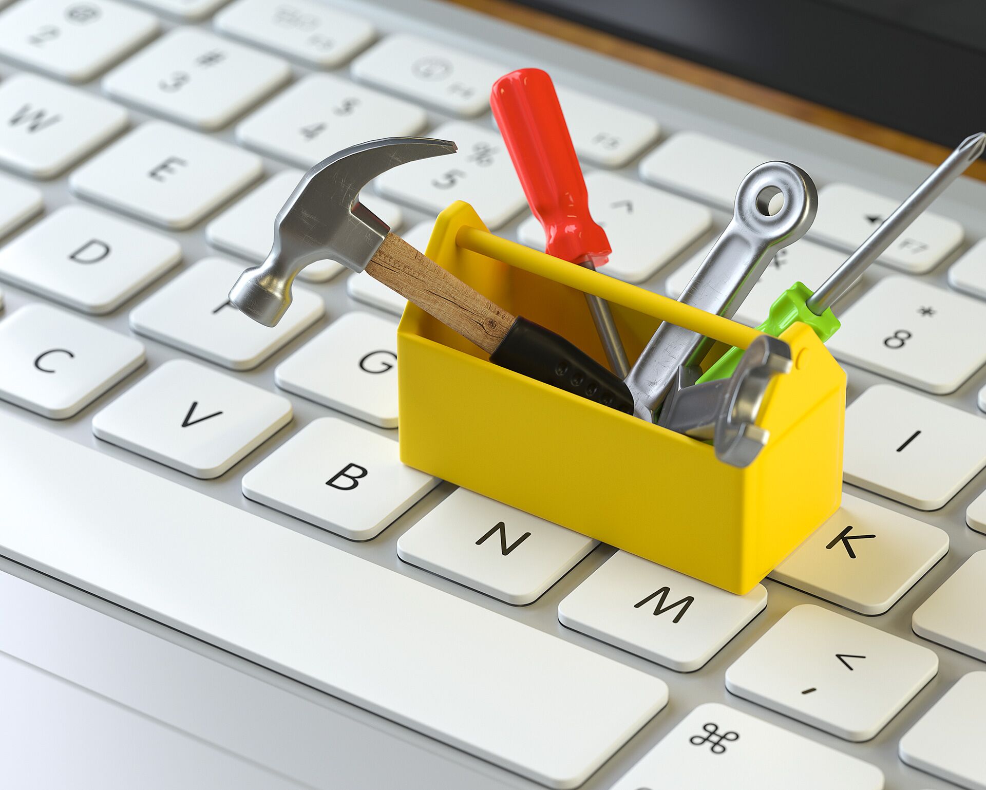 Kleiner gelber Werkzeugkasten auf Tastatur als Symbolfoto für Infoboxbeitrag „Website-Betreuung nach Veröffentlichung”