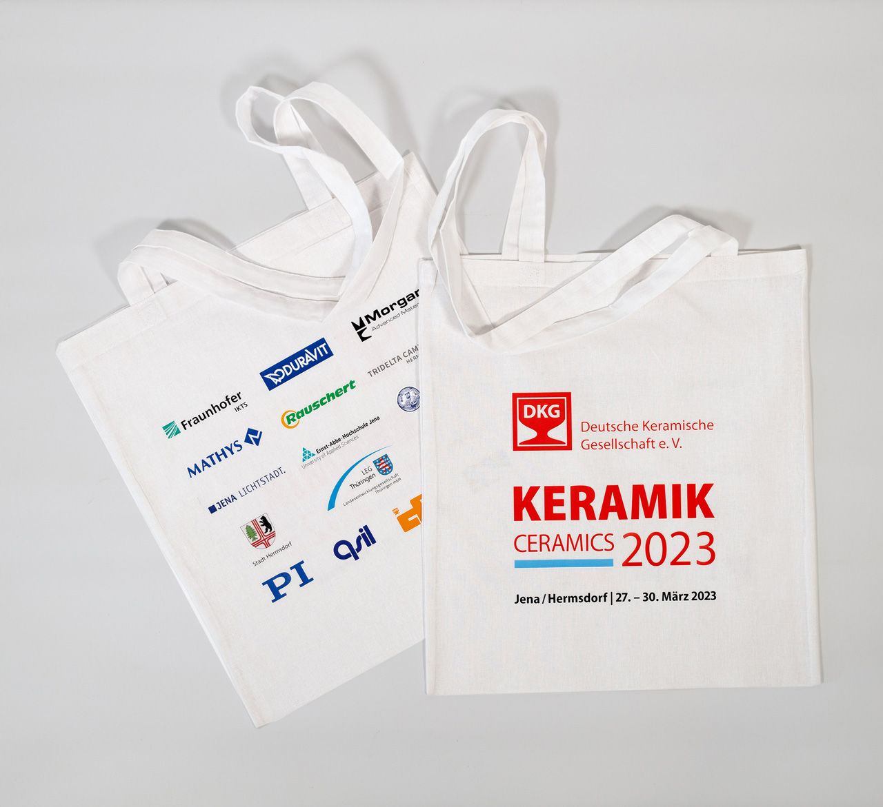 weiße Baumwolltasche mit rotem DKG-Logo und Schriftzug KERAMIK 2023