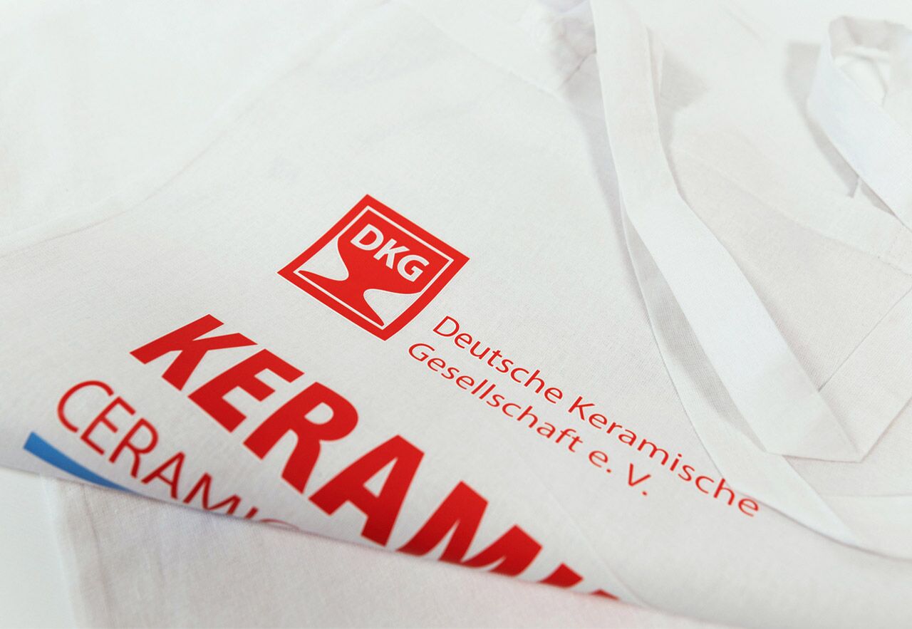Eventkommunikation: Weiße Tagungstasche mit rotem DKG-Logo