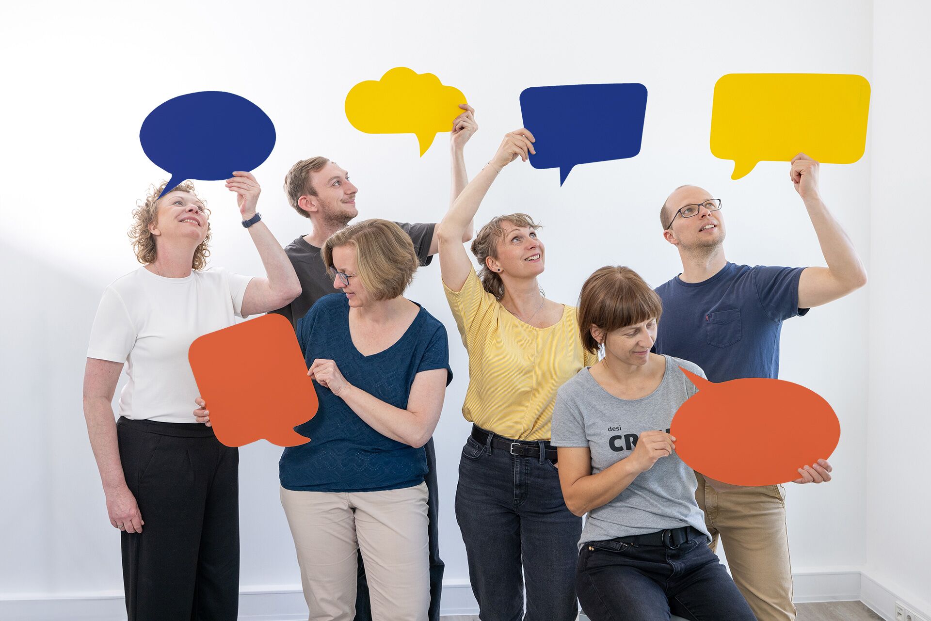 Unser Team mit kreativen Sprechblasen aus Papier – strategisches Design für Marken mit Haltung