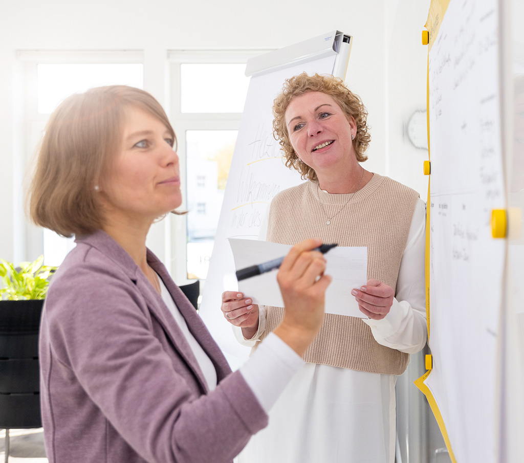 Anja Eglmeyer erarbeitet mit Workshop-Teilnehmerin strategische Fakten für die neue Website am Whiteboard
